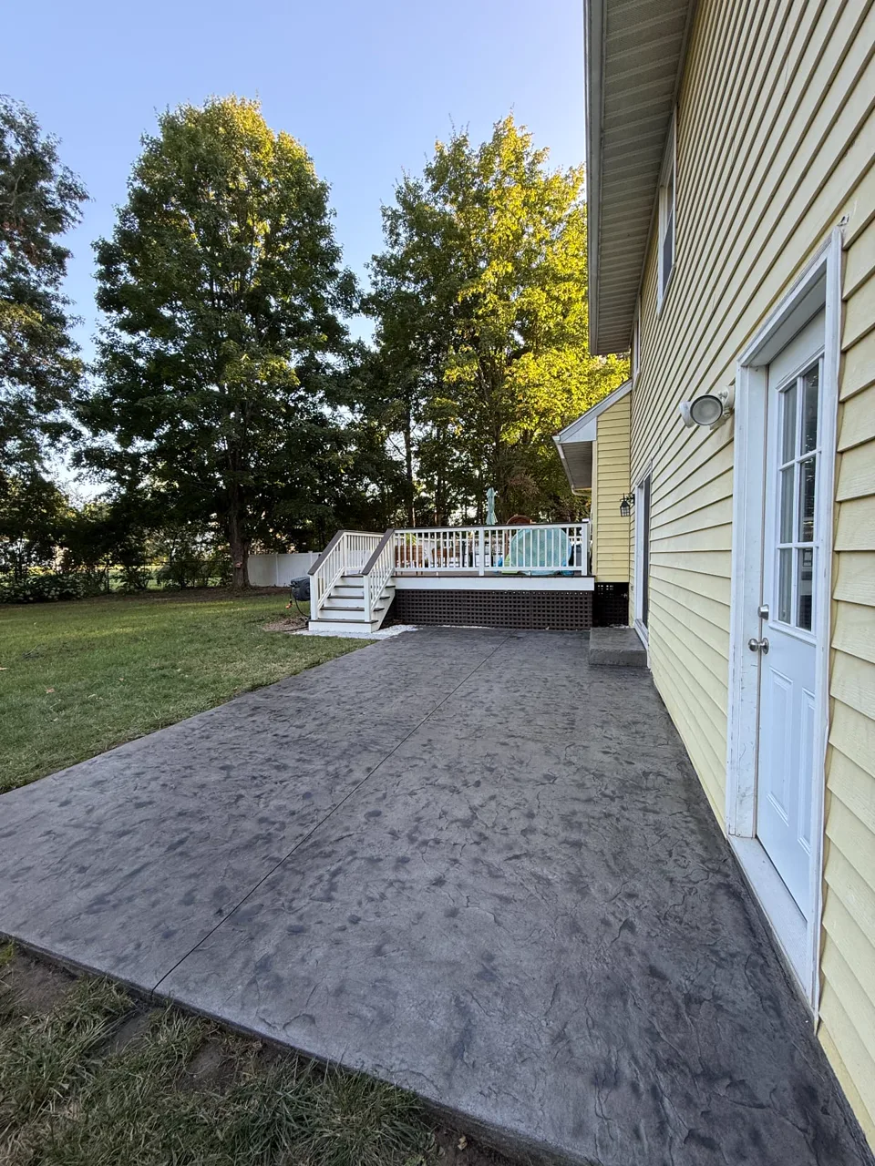 Finished dark gray stamped concrete patio beside a Capital Region home