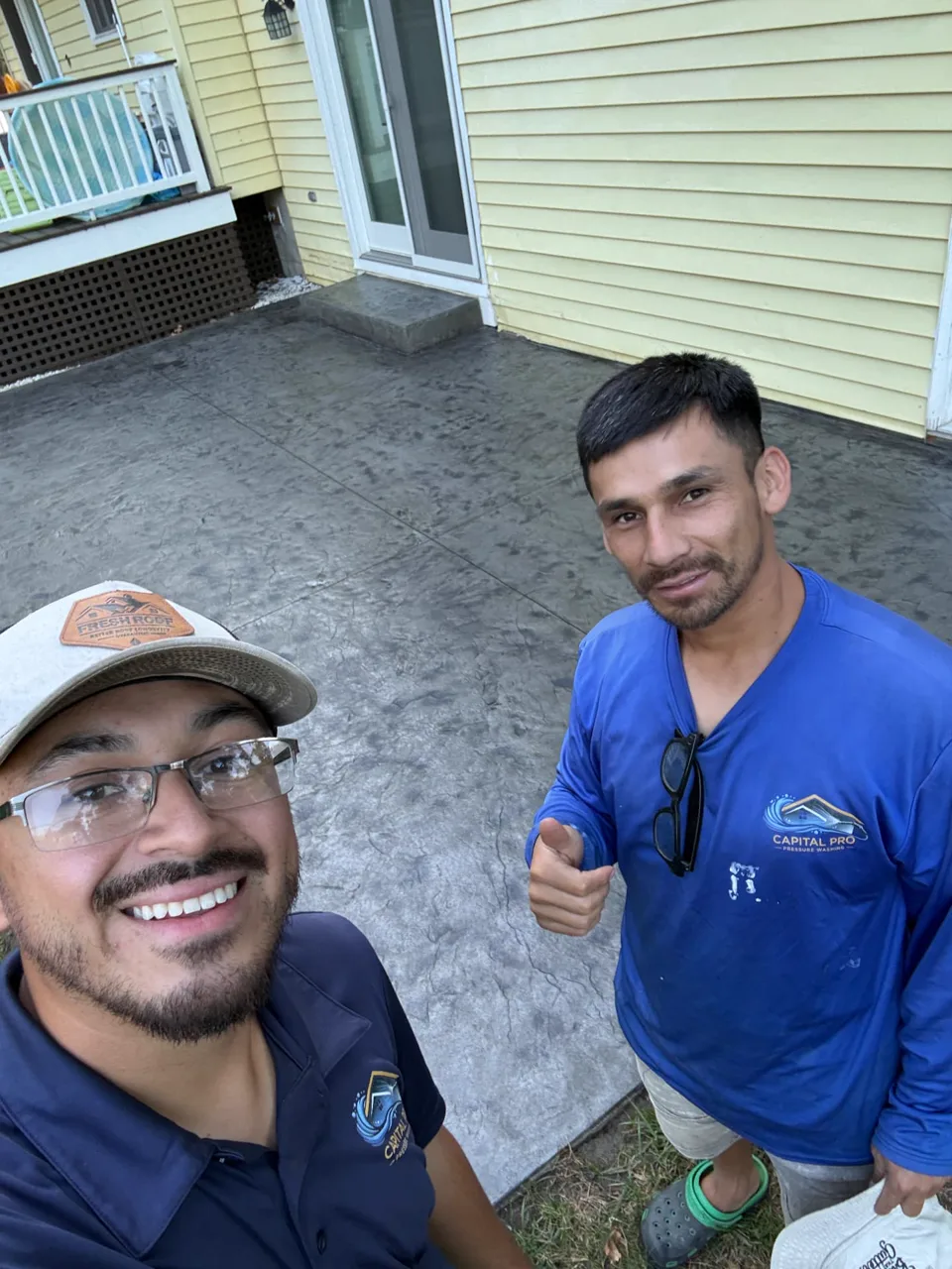 Capital Pro crew beside a finished dark gray stamped concrete patio